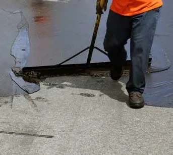 Asphalt Contractor spreading seal coat solution on pavement in Jacksonville FL