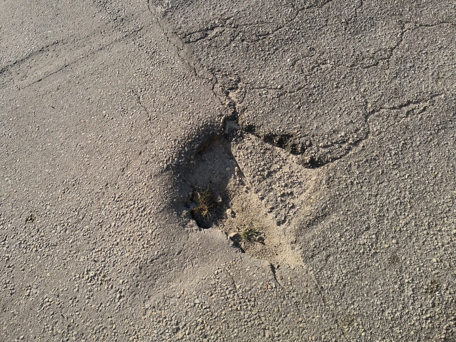 Pothole in need of repair on asphalt driveway jacksonville, fl